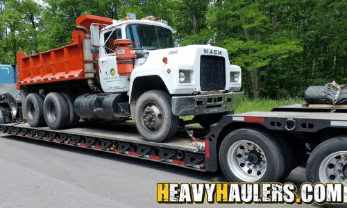 Hauling a Mack dump truck on a trailer.