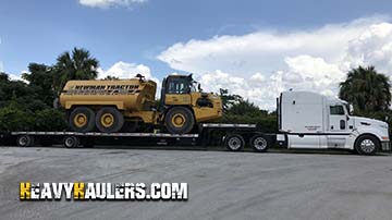 Trasnsporting a John Deere articulated water tank truck.