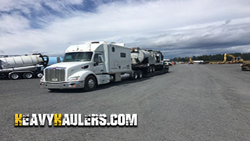 Hauling an International vacuum truck.