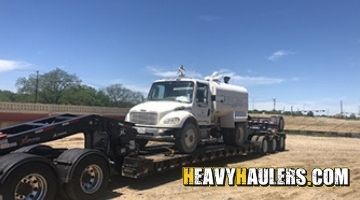 Transporting a Freightliner water truck on an RGN trailer.