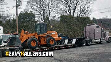 Loading a Case 621Z wheel loader on a trailer.