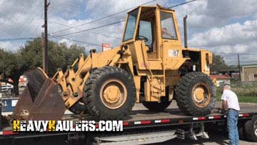Strapping a Caterpillar wheel loader for transport.