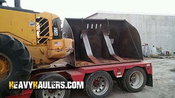 Hauling a Volvo wheel loader and a high tip bucket.