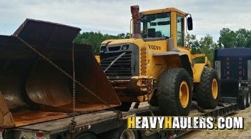 Strapping a Volvo wheel loader for transport.